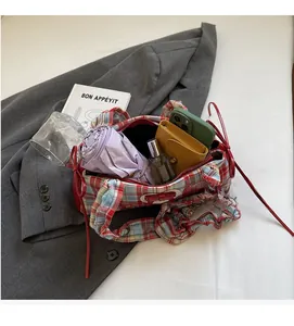 Detail view of large interior capacity showing phone, umbrella and wallet inside checkered bag