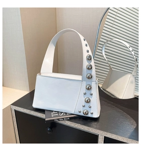 Close-up of white minimalist underarm bag with gradient silver stud decorations