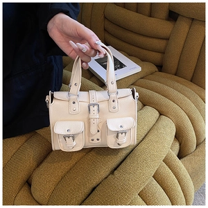 Detail of cream white leather bag with silver buckles and lychee texture finish