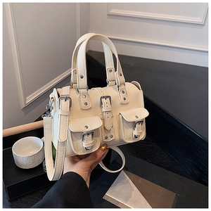 Detail of off-white lychee leather Boston bag featuring buckles and silver hardware