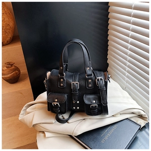 Detail of black pebbled leather handbag with silver buckles and dual front pockets