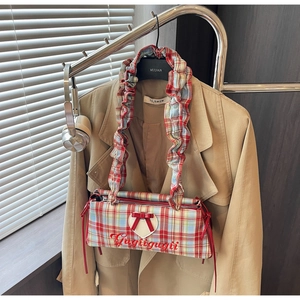 Detail of plaid tote bag with heart patch, red bow, and ruffled shoulder strap