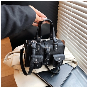 Detail of black lychee grain leather handbag with silver rivets and multi-pocket design