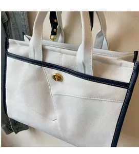 Detailansicht der Canvas-Tasche mit Kontrast-Lederbesatz und goldenem Drehverschluss