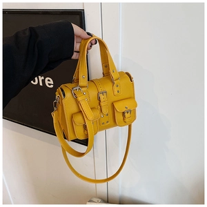 Macro detail of the bright yellow lychee leather texture and functional metal buckles