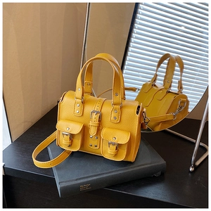 Detail of yellow lychee pattern leather Boston bag with pocket buckles and handle