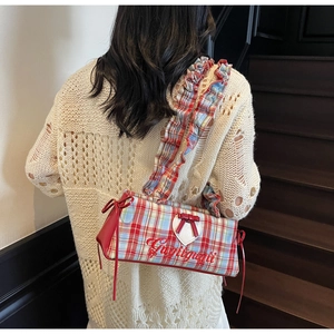 Detail of red and blue plaid tote bag with Gugigugii embroidery and ruffle strap design