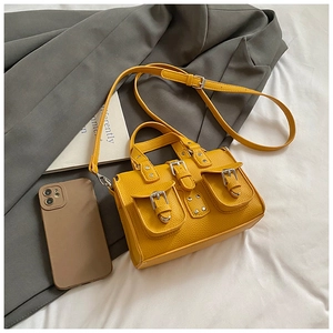 Detail of yellow lychee grain leather bag with silver buckles and multi-pocket design
