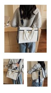 Détails du sac fourre-tout en toile beige avec bordure marine et fermoir doré