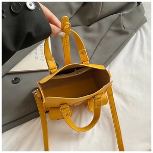 Close-up of the bright yellow leather handbag showing interior space and zipper pocket