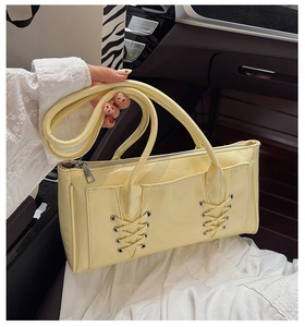 Gros plan du sac à bandoulière beige en similicuir avec laçage corset et fermeture éclair