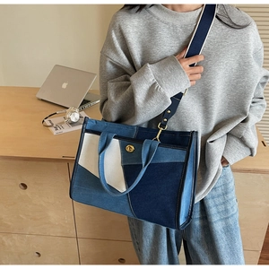 Detail der Denim-Einkaufstasche im Color-Block-Design mit goldenem Drehverschluss