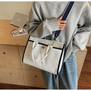 Détail du sac fourre-tout avec bandoulière marine, fermoir doré et ordinateur