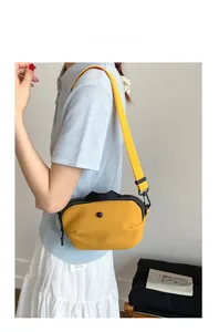Détail du sac bandoulière en nylon jaune de forme demi-lune avec fermeture éclair noire