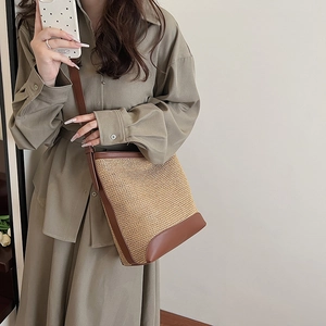 Summer woven straw tote bucket bag with leather shoulder straps and minimalist style