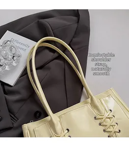 Détail des bandoulières rondes confortables sur un sac cabas beige à lacets brillants
