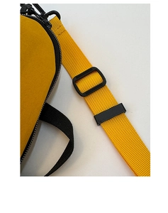 Gros plan sur la bandoulière en nylon jaune et la boucle noire réglable du sac à main