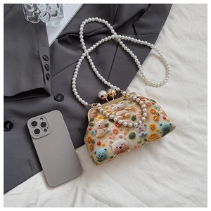 Detail of floral bear embroidery and pearl chains on an elegant vintage clasp bag