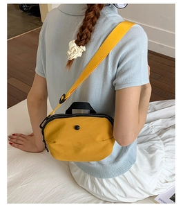 Détail de bandoulière et fermeture éclair noire sur sac bandoulière en nylon jaune