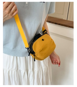 Détail du petit sac bandoulière jaune vif avec fermeture éclair noire et sangle large