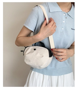 Détail d'un sac bandoulière léger en nylon blanc cassé avec fermeture éclair noire