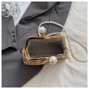 Detail of vintage floral tapestry kiss-lock bag with long pearl chain strap and metal frame