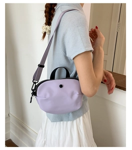 Vue détaillée du sac à bandoulière en nylon lavande avec sangle réglable et boucle noire
