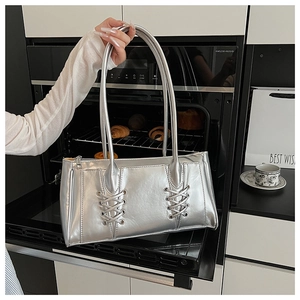 Vue détaillée du sac baguette argenté métallisé avec design à lacets croisés chic