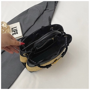 Interior view of straw woven bag with black leather trim and zipper pocket details
