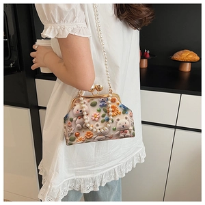 Close-up of a cute beaded crossbody bag with 3D crochet bears and floral decorations