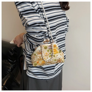 Close-up of pearl chain handles and 3D teddy bear floral print on shell bag