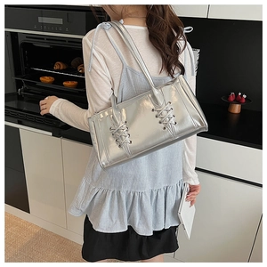 Détail du sac argenté miroir avec lanières croisées et finition métallique style Y2K chic