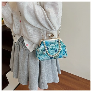Detail of blue cartoon bear floral bag with elegant pearl strap and metal clasp