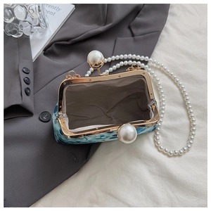 Close-up of floral print shell bag with pearl clasp and vintage metal frame opening