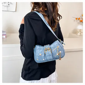 Detailansicht hellblaue Denim-Umhängetasche mit Sternanhängern und Retro-Schnalle