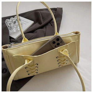 Détail du sac cabas beige avec laçage croisé unique et poche pour smartphone incluse