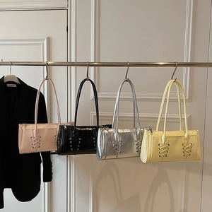 Sac sous l'aisselle en cuir verni avec laçage en rose, noir, argent et jaune pâle
