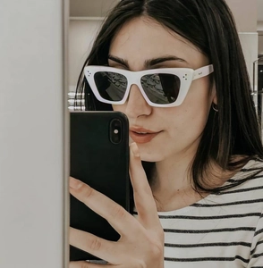 Close-up of white acetate square frame sunglasses with signature triple metal rivets