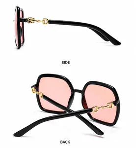 Detailoverzicht van retro vierkant zwart frame met roze glazen en gouden bitdetails