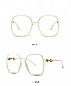 Detailweergave van beige witte oversized vierkante bril met goudkleurig metalen decor