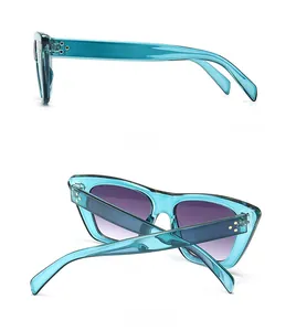 Detail view of turquoise translucent sunglasses frame with triple-dot silver rivets and side arms