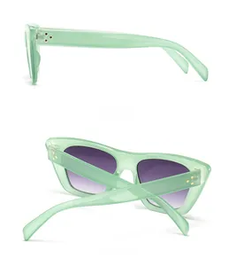 Detail view showing light green frame sunglasses with purple gradient lenses and gold rivets