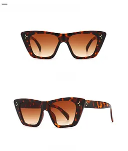 Detail view of leopard cat-eye sunglasses with golden rivets and brown gradient lenses
