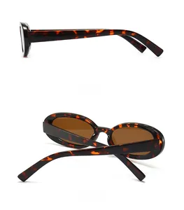 Detail view of oval retro sunglasses with dark tortoiseshell texture and brown lenses