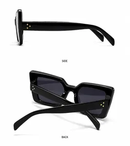 Detailansicht der schwarzen quadratischen Sonnenbrille mit markanten Goldnieten am Bügel