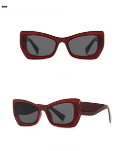 Macro view of butterfly cat-eye sunglasses with transparent red frames and grey lenses