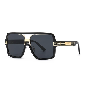 Oversized square sunglasses with black frame and gold metal bridge in a side view