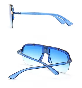 Detail view of large flat-top gradient sunglasses with blue frames and golden temples