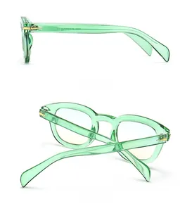 Detail view of translucent light green sunglasses frames with golden arrow hinges
