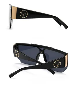 Detail view of oversized square sunglasses with gold deer head relief and wide temples